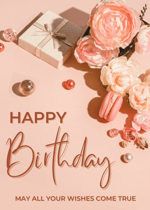 Blush pink birthday card with a styled flat-lay arrangement of soft-focus peach roses, pink macarons, pearl beads, and a ribbon-tied gift box, with bold text reading "HAPPY Birthday" and "MAY ALL YOUR WISHES COME TRUE."