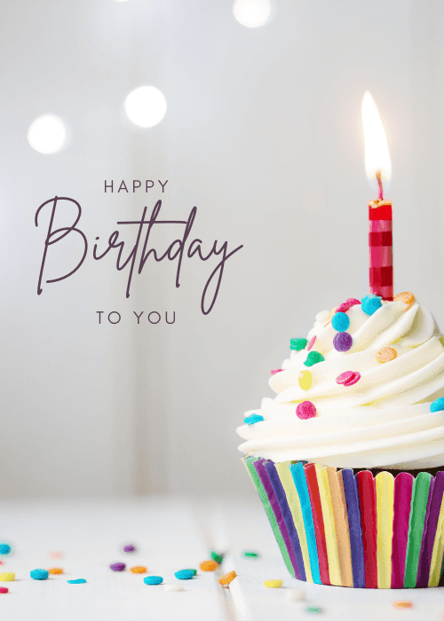 Photographic birthday card showing a single lit cupcake with colorful striped liner and rainbow sprinkles, with script text reading "Happy Birthday to You" on a soft white background.