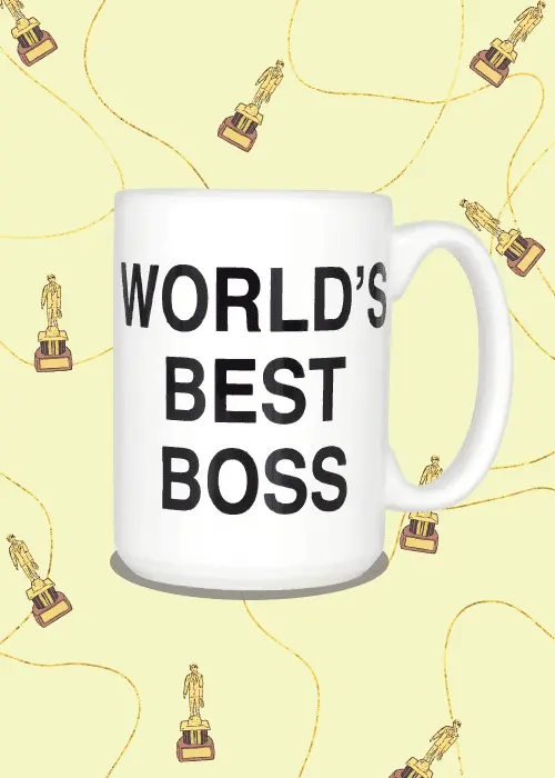 Large white World's Best Boss mug on pale yellow background with repeating pattern of gold award statuettes connected by swirling ribbon lines